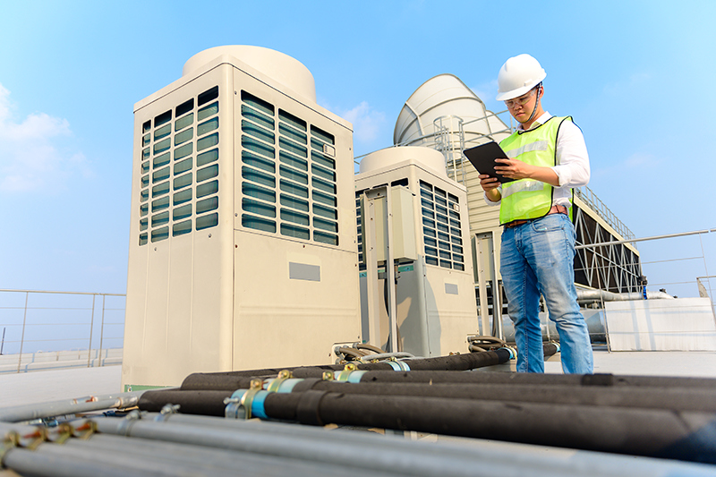 5 Commercial HVAC Maintenance Tips To Help Avoid Emergency Repair. Handyman going over a checklist.